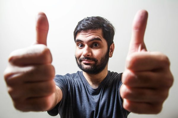 man in gray crew neck shirt making thumbs up
