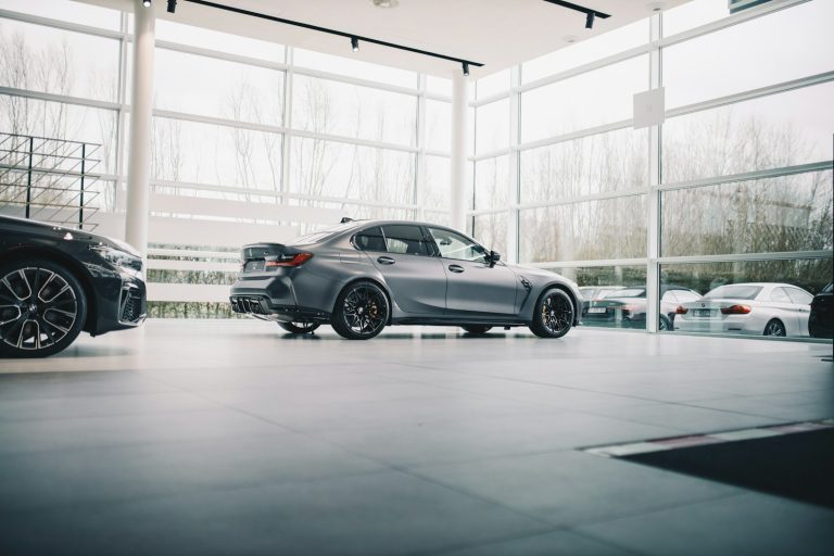 black coupe parked in a building; car dealership marketing